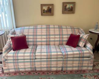 Queen sleeper sofa, truly "like new".  Accent pillows included.  Behind it are 2 "Autumn Road Scene" paintings.