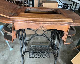 Antique sewing machine cabinet with cast iron base...yes, it needs some love, but you can do such great things with these...make it a bar, drop a perforated tub in the opening and turn it into a planter for your garden with just a coat or two of Marine varnish...THINK!