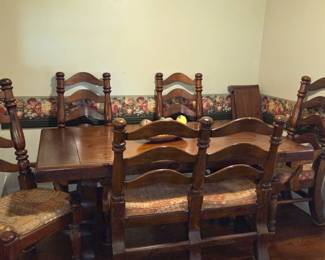 Wooden dining room table with 4 upholstered chairs and bench seating.