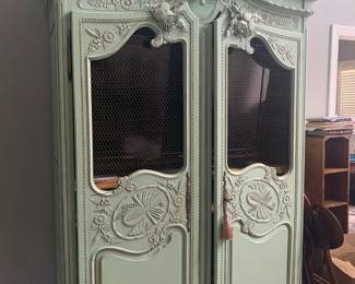 Beautiful extra large painted armoire. Just look at that hand carving! Shelving inside and would be easy to add a rod for clothing!
