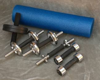 Lot 333. Three York dumbbells (one with no weights), two Reebok 5- pound dumbbells. Ab wheel. Foam roller.