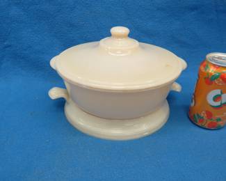 Lot 371. Two-quart Ivory Fire-King casserole dish with lid and trivet