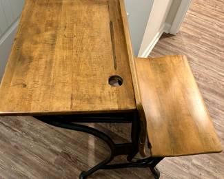 Antique Schoolhouse Desk
Classic wood and cast iron school desk with attached seat. Features original ink well hole and carved doodles from its school days, adding authentic character and charm. Perfect as a decorative accent, conversation piece, or for nostalgic display.