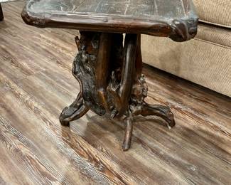 Rustic Root Base Side Table
Unique hand-crafted side table featuring a natural wood root base with organic branching form and a dark-stained plank top. The table’s irregular edges and natural character give it a rugged, one-of-a-kind look — perfect as an accent table in a lodge, cabin, or rustic living space.

Condition: Solid and sturdy, with visible wear on the tabletop consistent with age and use, adding to its rustic charm.

Dimensions: Approx. 24” W x 20” H x 18” D