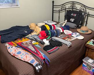 Tons of miscellaneous hats and metal bed frame with mattresses