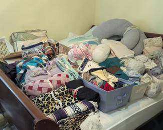 lots of bedding, blankets, sheets, etc, on this king size bed