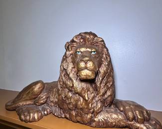 Gold laying lion statue with gorgeous blue eyes
