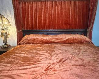 King-sized bed with canopy - A bed a king could love. Hand-carved wood with glass ceiling, velvet drapery, and bedspread to match. From His Elvis area