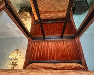 King-sized bed with canopy - A bed a king could love. Hand-carved wood with glass ceiling, velvet drapery, and bedspread to match. From His Elvis area