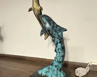 sculpture depicting two dolphins leaping from a wave