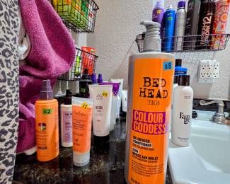Many unused (and used) hair gels, curl cream, shampoo/conditioner, oil, frizz eaze, and more!