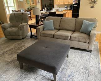 recliner, sofa, ottoman, large area rug.  Grays and tan colors.