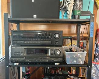 Vintage Spurs cereal, JBL speakers, multiple receivers/equalizers, binoculars, iPad case, CDs, patriots, and cords.  