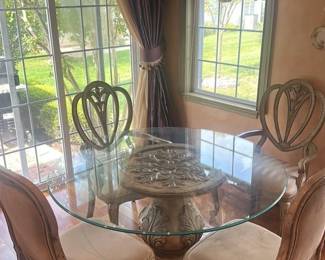 Round Glass Top Dining Table with Ornate Pedestal Base and Upholstered Chairs 
