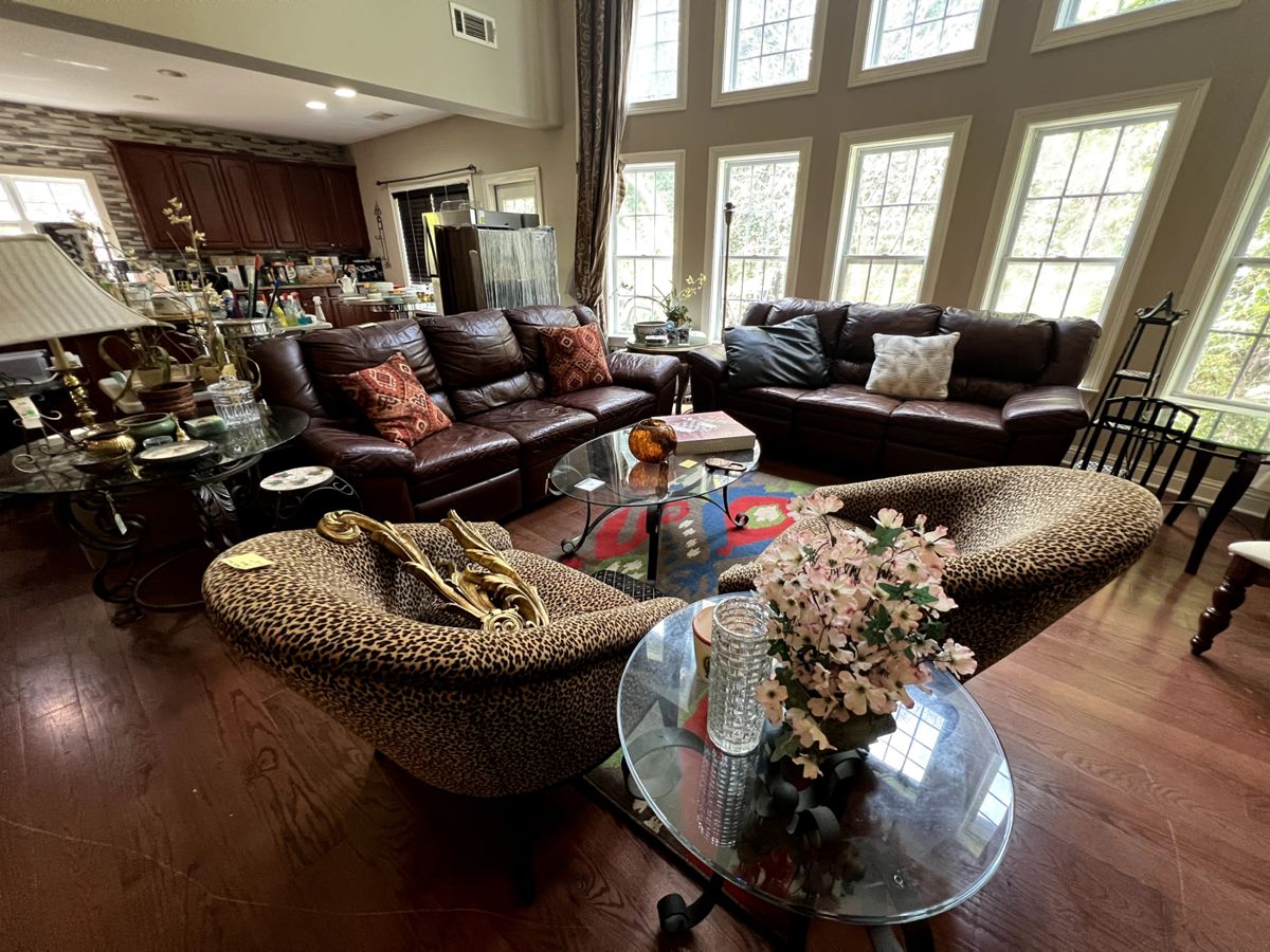 Leather couches, leopard print chairs, various glass-top tables, lighting and home decor
