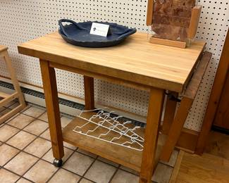 Butcher block kitchen island cart with a drop leaf and casters.