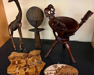 Carvings from Kenya and West Africa, including an interlocking wooden tribal art stand with a bowl featuring elephant motif, and an Akuaba fertility doll.