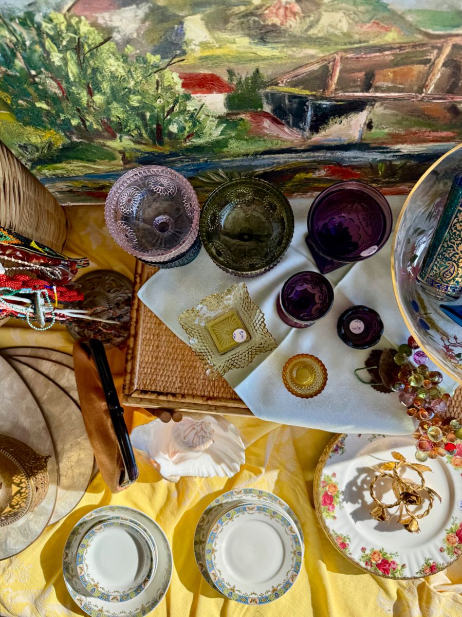 Original artwork, colored glassware, vintage beaded necklaces, vintage grapes, dinnerware, placemats. 