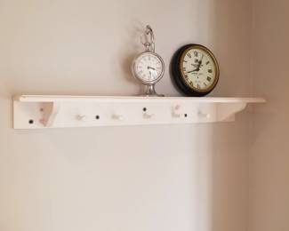 Shelf with pegs; clocks
