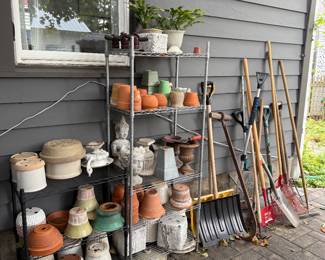 Backyard patio, with many gardening supplies and outdoor furniture.