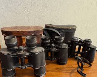 collection of vintage binoculars, likely from the early to mid-20th century,
