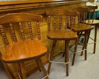 vintage pair of oak wood swivel bar stools in a rustic country colonial style.