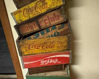 vintage wooden beverage crates, primarily featuring Coca-Cola crates in various styles and colors, along with a Sun-Pop crate and a Royal Crown Cola crate.