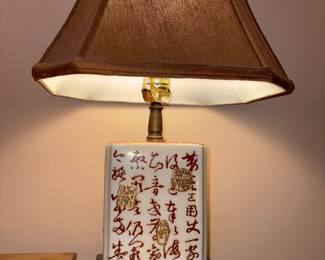 Oriental table lamp with characters on base or lamp. Brown lamp shade.
