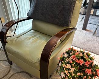 Leather armchair with wooden arms. Decorative faux flower arrangement.