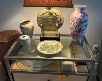 Side table with drawers and glass top. Candles, decorative plates and bowls. Vases and lamps for sale.