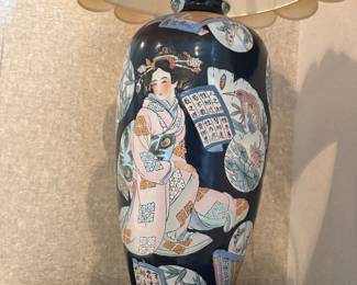 Beautiful oriental inspired table lamp with distinct design of a geisha, bamboo and lily pads. Pink and blue hues on navy blue base. Lamp shade is ivory.