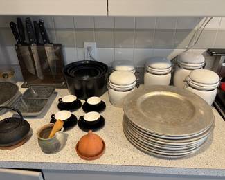 Charger plates, small mortar and pestle, set of flour and spice canisters, set of black espresso cups and saucers, tea kettle, spice holder, mixing bowls, knives and decorative bowls for sale.