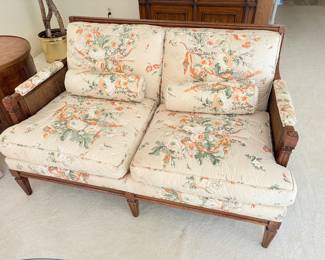 Two cushion upholstered loveseat with cane detailing on side