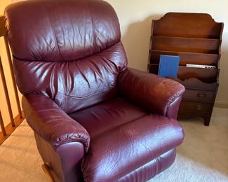 Maroon leather recliner and wood magazine/book rack