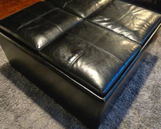 Black ottoman-four compartments that open and function as tv trays or a table for breakfast in bed or entertaining. Four compartments for storage. Heavy, and sturdy and shaped like a square. Excellent condition -35x35 x 18