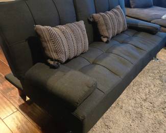Grey futon couch that folds into a bed and in great condition. Comes with two Grey boho pillows and has silver legs as shown. Middle row folds down for cup holder access. 