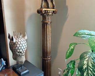 A large floor torchiere 71" tall in an Elephant motif. The item was created with good detail by the artist and depicts 3 elephants facing outward atop a large fluted ionic column with trunks proudly raised of which a light shade is attached on their backs. as in condition