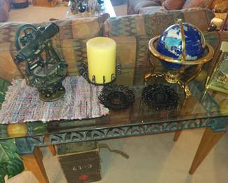 Antique transit (sextant?) and a fancy globe on glass top sofa table.