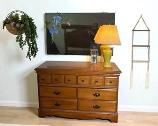 Wooden Dresser with Mirror, Yellow Table Lamp, and Wall Decor
