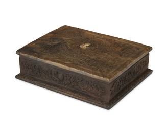 1379
A Renaissance Revival-style jewelry box
Mid/late 20th century
The molded resin box with acanthus leaf motifs throughout, the hinged top adorned with a central profile of a maiden, revealing an interior lined in black felt
3.625" H x 11.375" W x 9" D
Estimate: $300 - $500