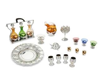 1484
A Farber Brothers barware set
Early/mid-20th century; New York, NY
Most variously marked for Faber Brothers
Each glass with metal overlay, comprising a tantalus with three bottles, another decanter, four dessert cups, one taller dessert vessel, and three shot glasses, together with four Chase U.S.A. nickel-plated copper goblets, a nickel-plated charger, and a nickel alloy turtle-form toothpick holder
16 pieces
Tantalus overall: 10.5" H x 13" W x 3.75" D; Each dessert cup: 3.625" H x 3.875" Dia.
Estimate: $200 - $300