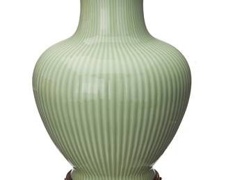 1395
A Chinese celadon glazed ceramic vase
20th century or later
Bearing an apocryphal reign mark for Qianlong Period (1736-1795) in blue underglaze
With shallow lobed body and flared rim, set on a carved wood stand
Vase: 14.5" H x 11.25" Dia.; Stand: 1.5" H x 7.75" Dia.
Estimate: $400 - $600