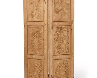 1384
Two Mexican carved wood doors
Early 20th century
The double-sided doors of mortise and tenon construction joined by hinges, featuring friezes depicting floral and avian motifs, cherubs, and a church, surmounted by later carved accents and finials
Each panel: 79" H x 18.625" W x 2" D
Estimate: $500 - $700