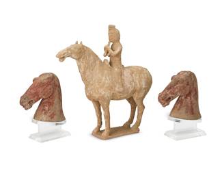1396
Three Chinese pottery horse figures
Han Dynasty (206 BCE-220 CE) and Tang Dynasty (618 CE-907 CE)
Comprising a Tang Dynasty equestrienne rider on horseback playing a flute, and two Han Dynasty terracotta horse heads, each mounted to an acrylic stand
3 pieces
Equestrienne: 13.5" H x 13.25" W x 4.5" D; Each head: 6" H x 6.25" W x 2.375" D
Estimate: $400 - $600