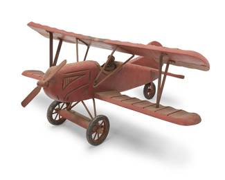 1441
A carved wood model biplane
Early/mid-20th century
The painted wood airplane with with pilot figure, iron supports, axel, and propeller, and rubber wheels
13" H x 29.5" W x 27" D
Estimate: $100 - $200