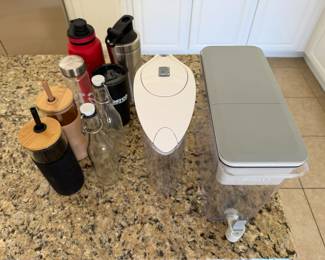 Two Brita water jugs, an assortment of drink bottles and  glass tumblers with straws