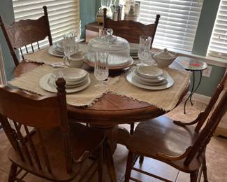 Round table with 4 chairs. It has a leaf, which makes it an oval shaped, with 2 more chairs
