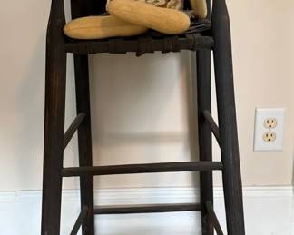 Primitive Doll Sitting In Black Rustic Chair