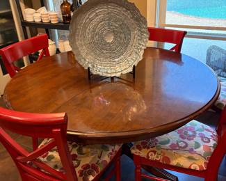 Solid wood round dining table with six chairs. The chairs are covered upholstered.