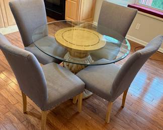 Round Glass-Top Dining Table with Pedestal Base and Four Upholstered Dining Chairs